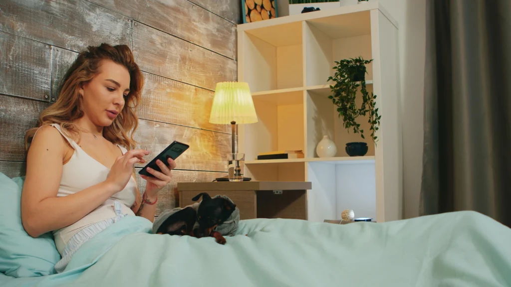 woman scrolling on her phone before bedtime